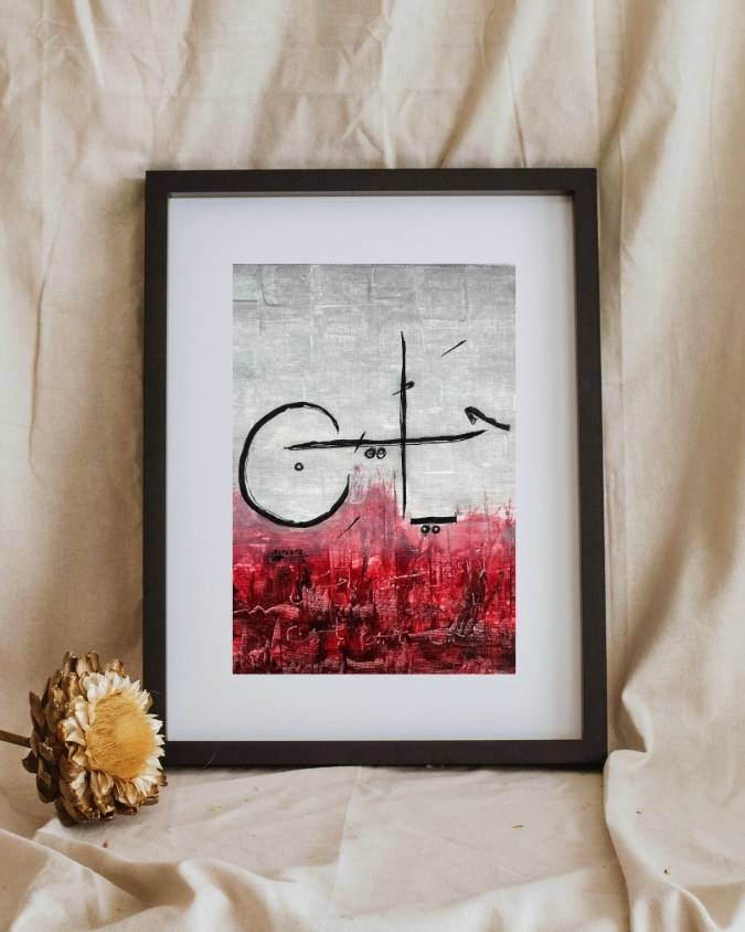 Framed Ya Hussain Karbala painting resting on cream fabric, black calligraphy above a crimson ground
